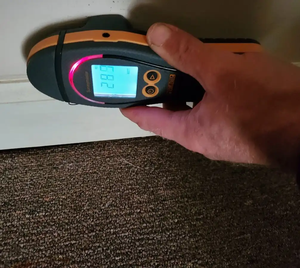 Moisture detection at baseboard during Storm Damage Restoration in Plainview